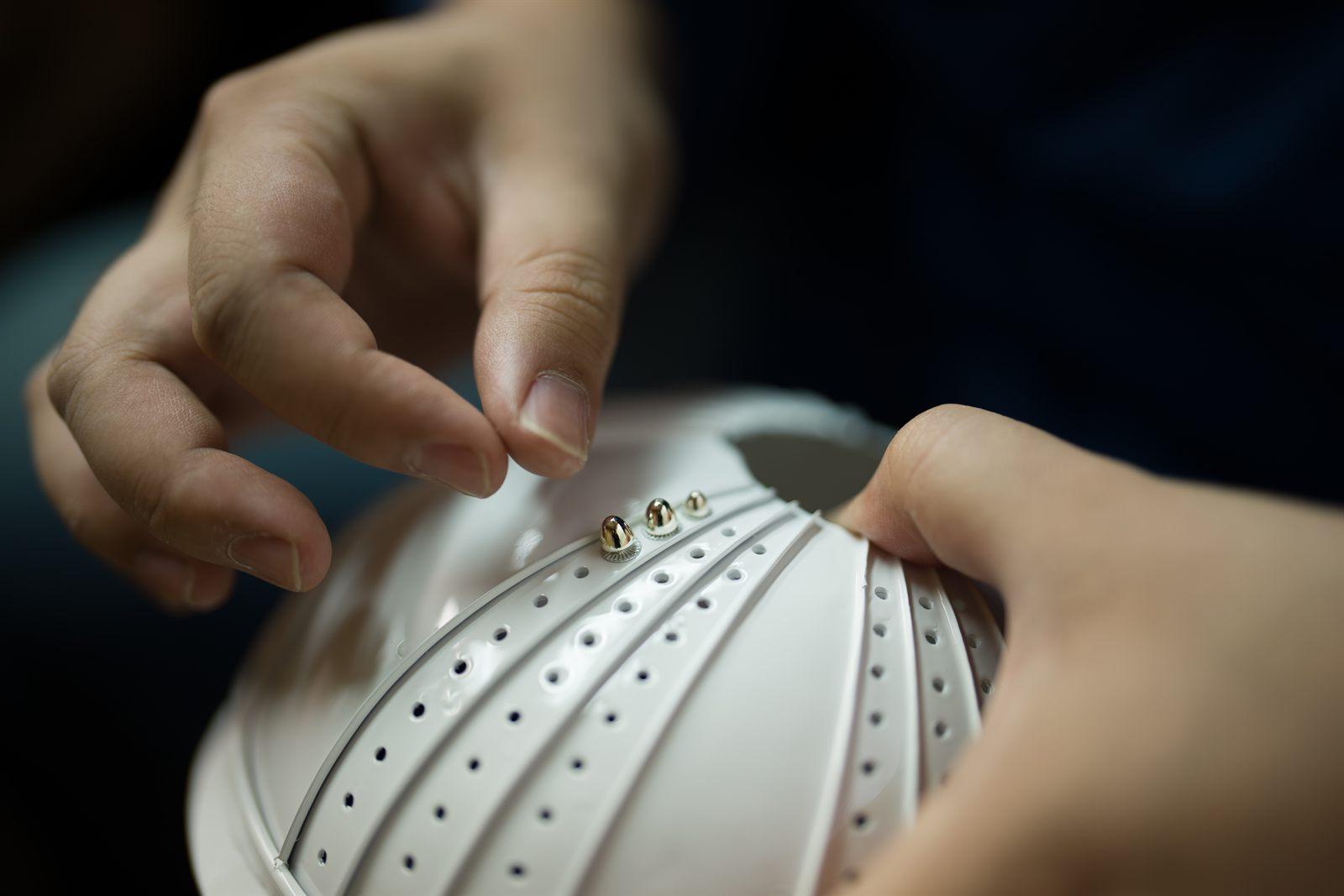 Setting gold rivets on the kabuto bowl